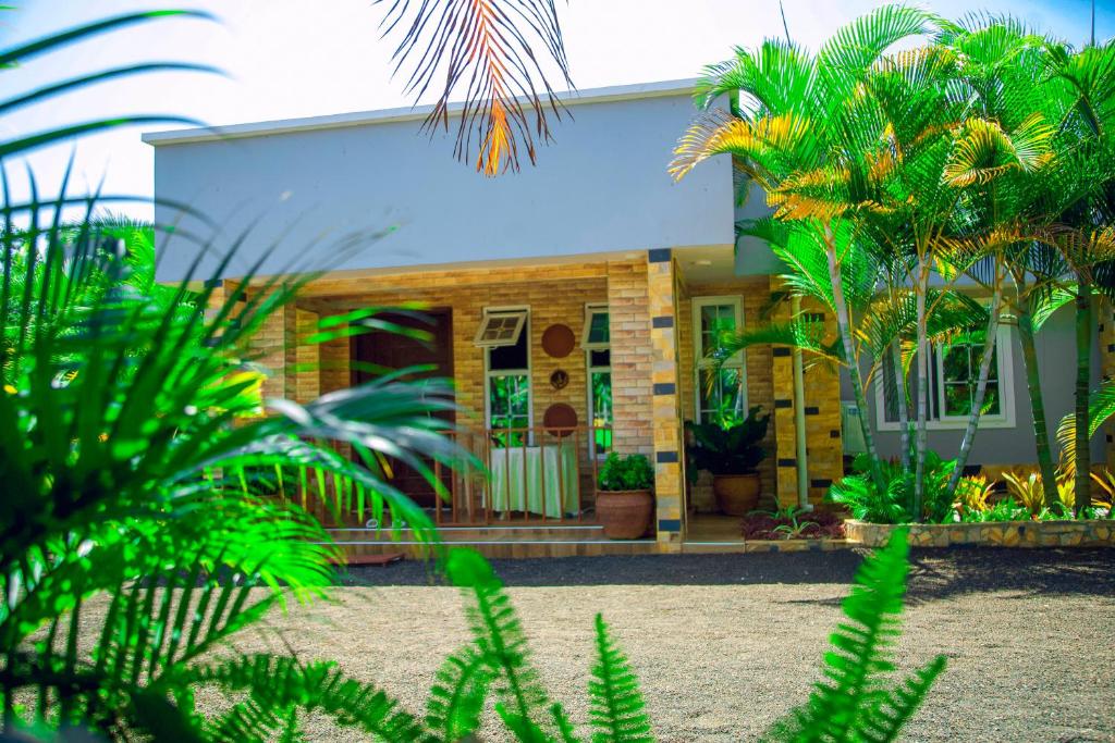 a house with palm trees in front of it at Rhovee Homes in Moshi