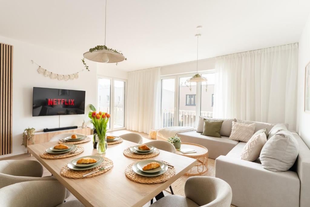 a living room with a table and a couch at Premium-Apartment mit Balkon - Perfekt für Familien, Gruppen und Geschäftsreisende - ZAYA STAYS in Leipzig