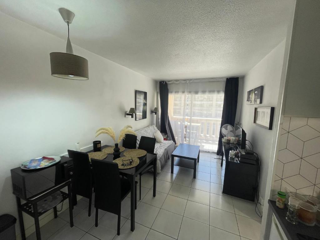 un salon avec une table et un canapé dans l'établissement Appartement T2 bord de mer piscine 2025, à Cannes