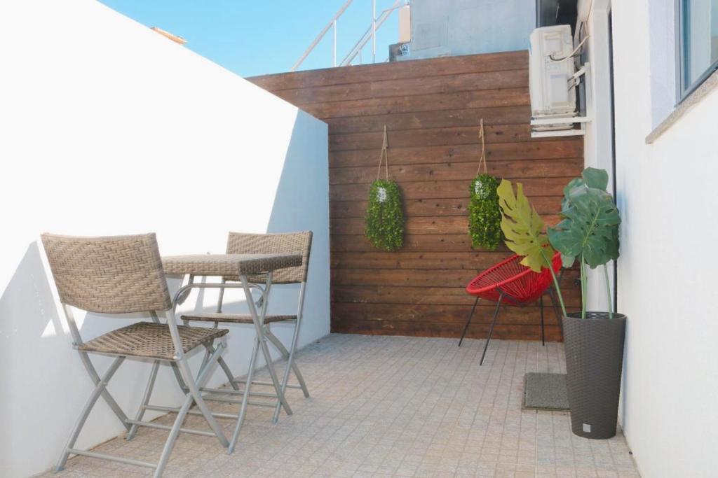 a patio with chairs and a wooden wall at 9 min Metro to Downtown -Remote working - Free Parking in Porto
