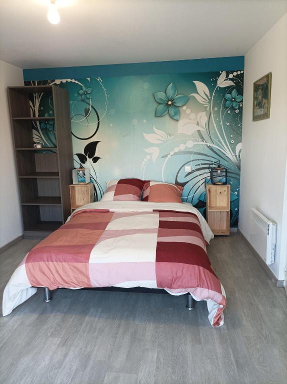 - une chambre avec un grand lit et un mur fleuri dans l'établissement Chez Sabine la Campagne HAUT, à Narbonne