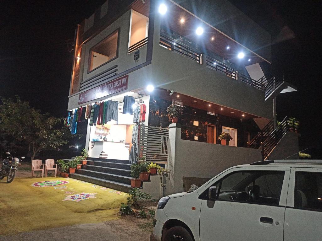 a white car parked in front of a building at night at Mamatha Guest inn in Hampi