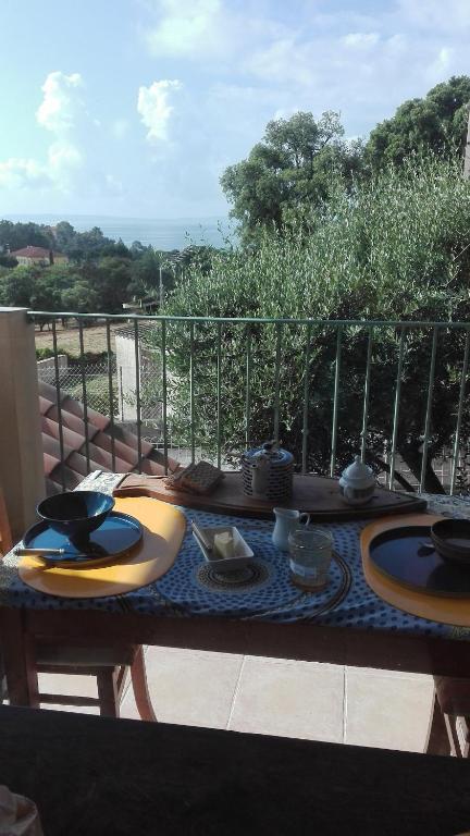 une table avec des assiettes de nourriture sur un balcon dans l'établissement bastidon, 5 people near beach, sea view, quiet, au Lavandou