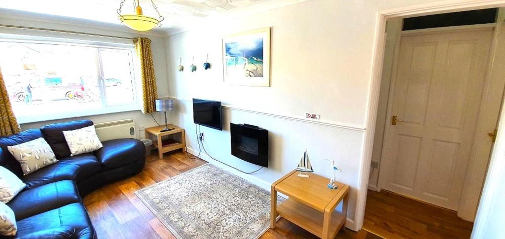 ein Wohnzimmer mit Sofa und Fernseher in der Unterkunft 7 Penhale in Perranporth