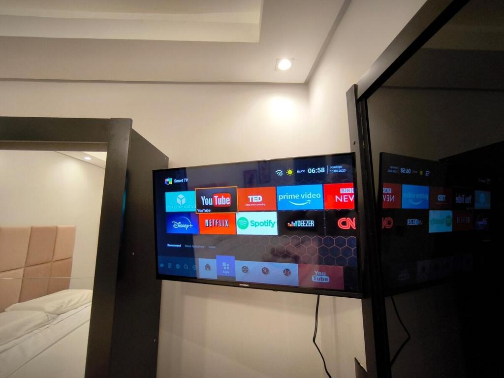 Un televizor și/sau centru de divertisment la Grey Suite - Centro Ar Cond Wi-Fi TV Smart