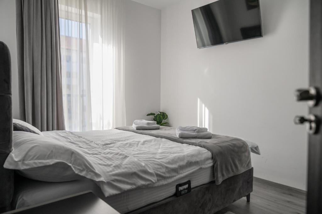 a bedroom with a bed with towels on it at NexuS Apartments in Sibiu
