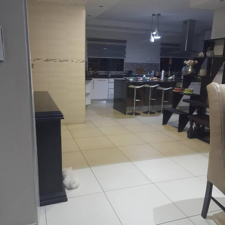 a kitchen with tables and stools in a room at Nduma Paradise Villa in Darkton