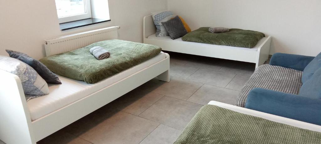 a room with two beds and a couch at TOPFLAT mit Küche I gratis Parkplatz I zwei Schlafzimmer I zentrumnah in Dortmund