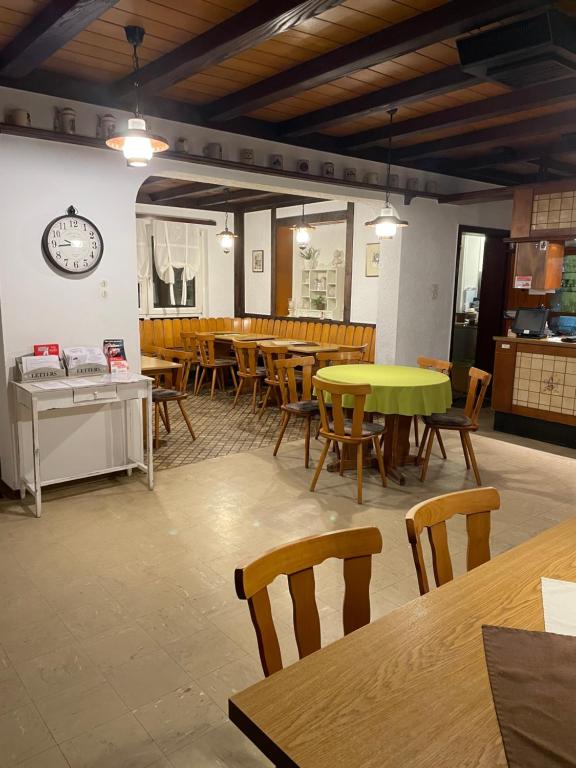 a restaurant with tables and chairs and a clock on the wall at Gaststätte Wiesengrund in Groß-Gerau