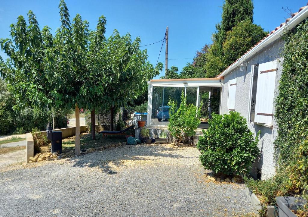 une maison avec une cour arborée devant elle dans l'établissement villa des coteaux, à Ners