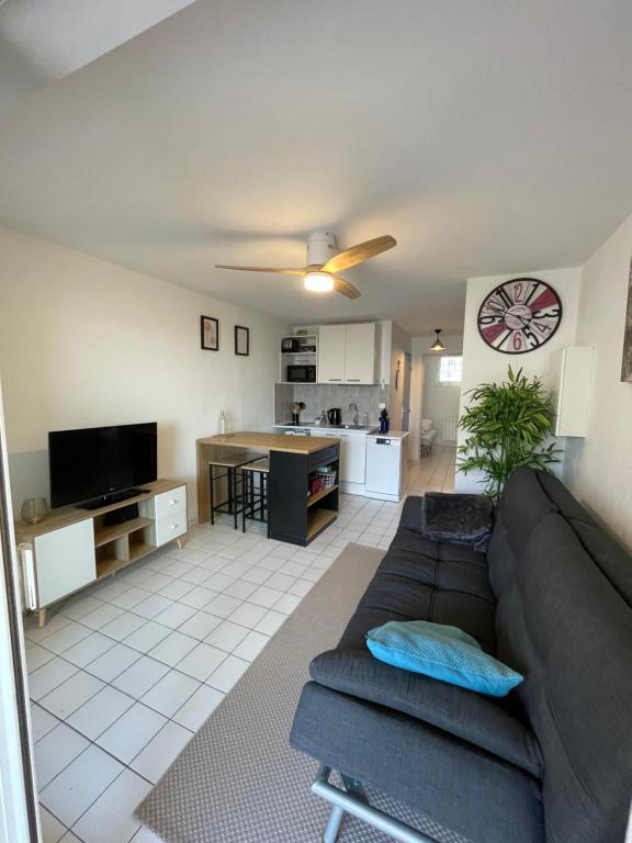 un salon avec un canapé et une cuisine dans l'établissement Plages & Marina - joli T2 à 200m des plages Sète, à Sète