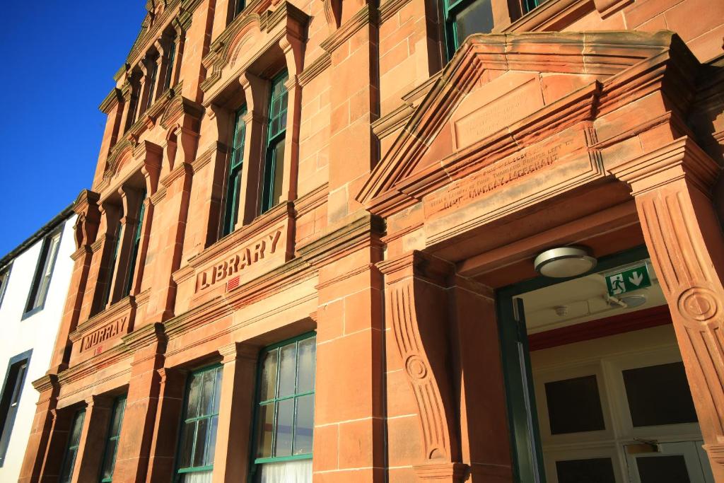 um edifício de tijolos com uma placa na lateral em Murray Library Hostel em Anstruther