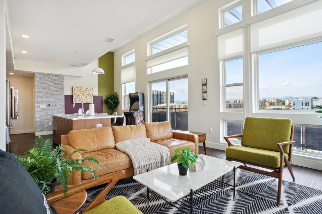 a living room with a couch and chairs and windows at 2880 Skyline Penthouse at Espadin in Denver