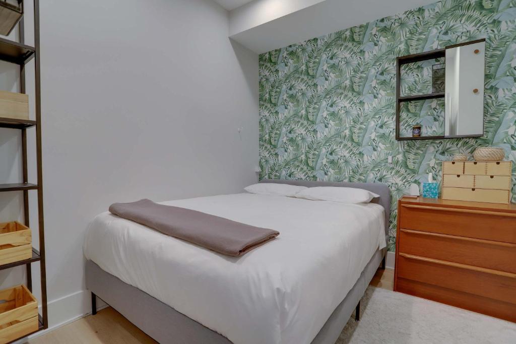 ワシントンにあるSojourn Condo in NW DC 2 blocks to Shaw Metroの緑の壁の小さなベッドルーム(ベッド1台付)