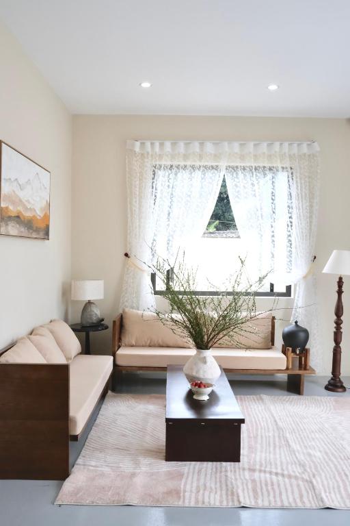 a living room with a couch and a window at Panacea The Villa in Mộc Châu