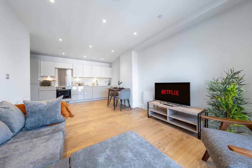 Una sala de estar con un sofá y un televisor. en ZAI Stays- LutonTown NEWModern 2bed flat, en Luton