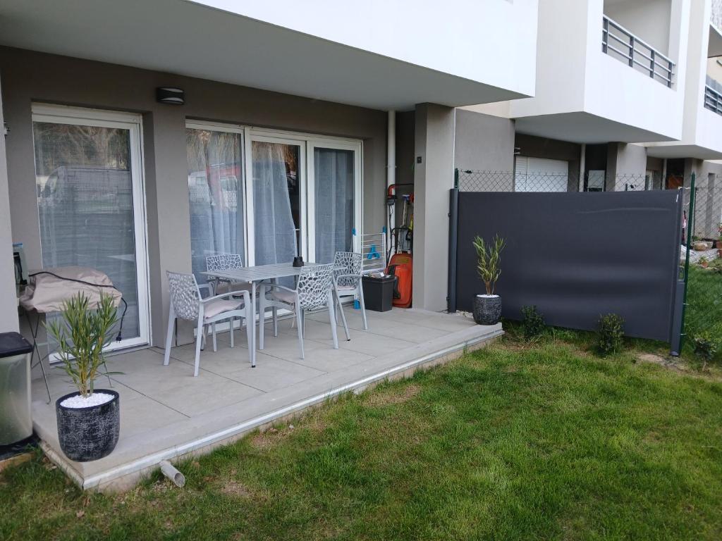 une terrasse avec une table et des chaises dans une maison dans l'établissement Superbe appartement neuf, à Six-Fours-les-Plages
