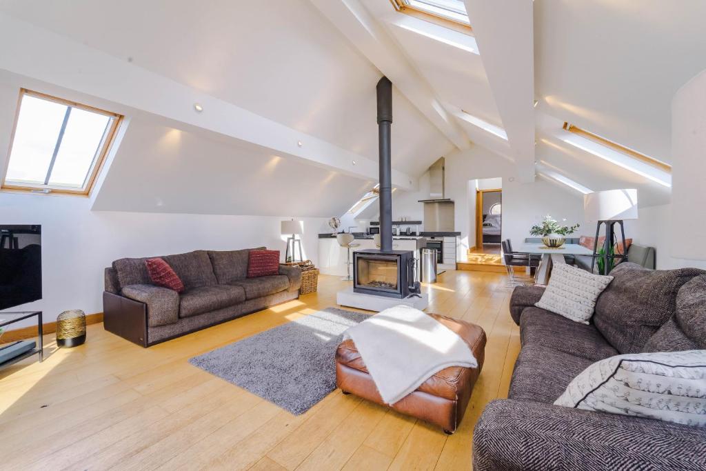 a living room with two couches and a fireplace at Cobstone Cottage in Walmersley