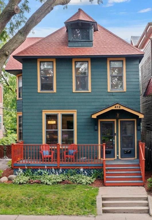 a blue house with two chairs in front of it at Cathedral Hill Charm in Saint Paul