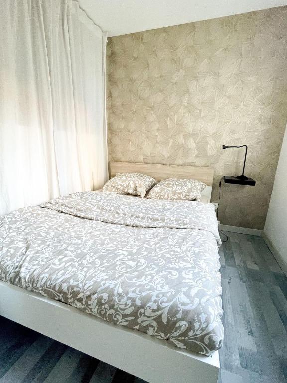 - un lit avec une couette blanche et 2 oreillers dans l'établissement Studio centre-ville Petite venise, à Colmar