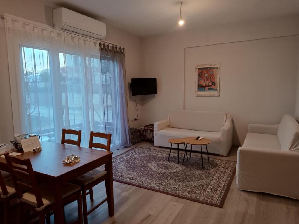 salon z kanapą i stołem w obiekcie Διαμέρισμα με δύο δωμάτια, δύο μπάνια w mieście Katsikás