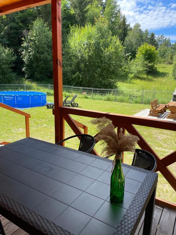 a table with a vase with a plant on it at Słoneczne wzgórze domki pod lasem in Swieszyno
