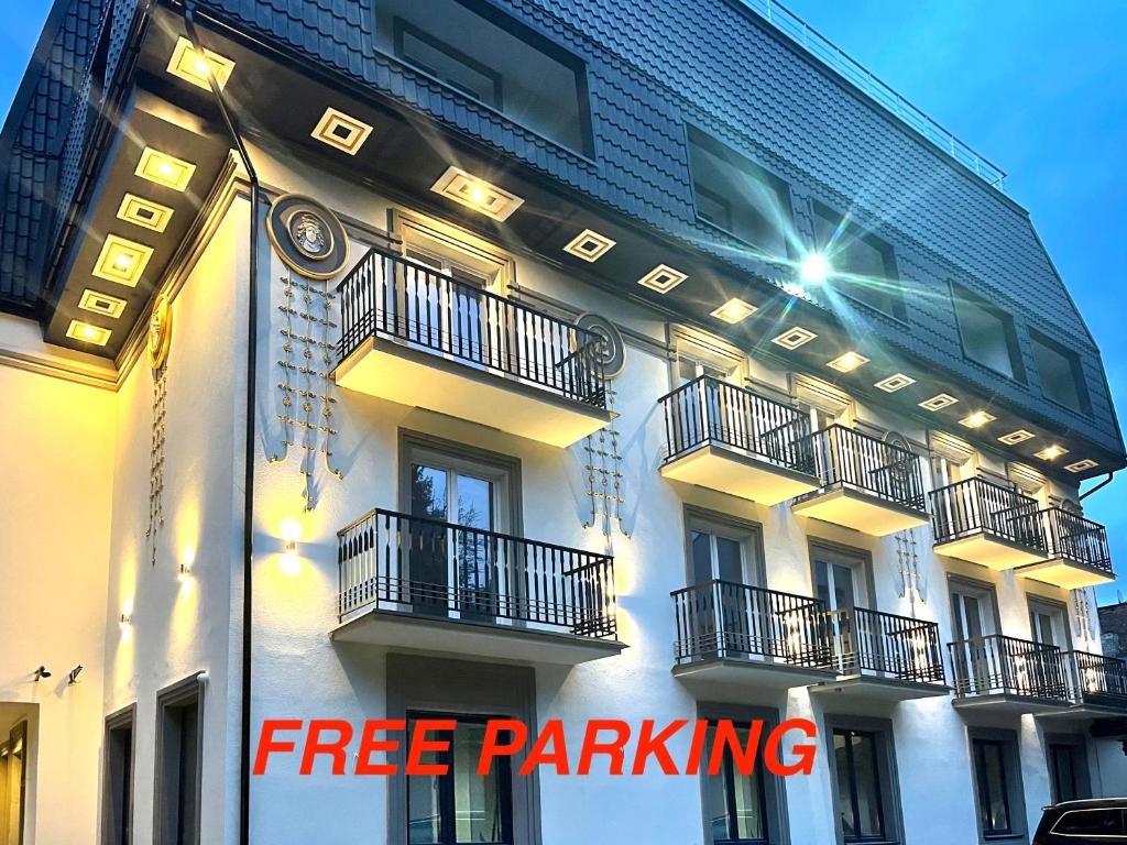 リヴィウにあるApartment Eneyのバルコニー付きの建物、無料駐車場を読むサイン