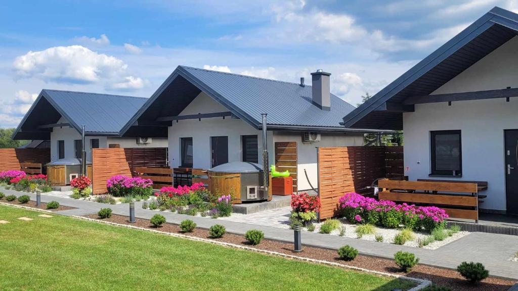 una casa con fiori nel cortile anteriore di Domki Magiczne Miejsce a Hużele