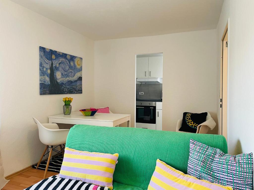 a living room with a green couch and a kitchen at Schönes 2 Zimmer Apartment, ruhig und gemütlich in Bremen