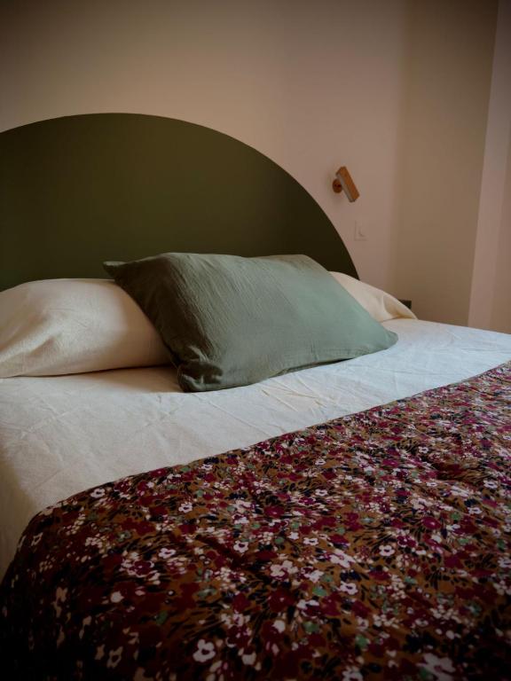 - un lit avec une tête de lit verte et un oreiller dans l'établissement Auberge U Pampasgiolu, à Galéria