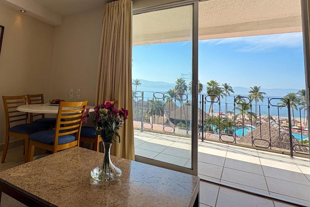 Una habitación con una mesa con un jarrón de flores. en Spectacular view & private terrace!, en Puerto Vallarta