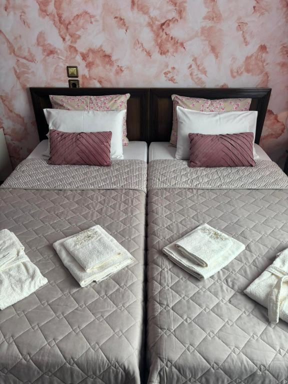 a bedroom with two beds with towels and pillows at Country Escape in Volos