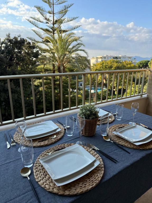 une table bleue avec des assiettes et des verres sur un balcon dans l'établissement Chic 2 bedroom with Huge Terrace and Pool Cannes, à Cannes
