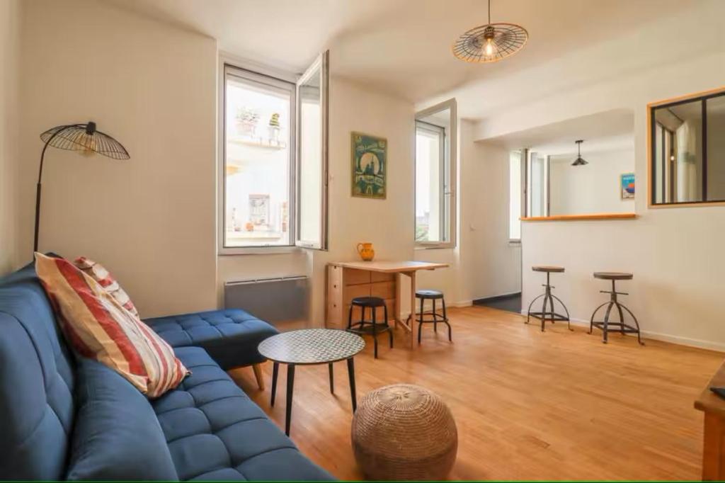 un salon avec un canapé bleu et une table dans l'établissement Chez Maddie, à Marseille