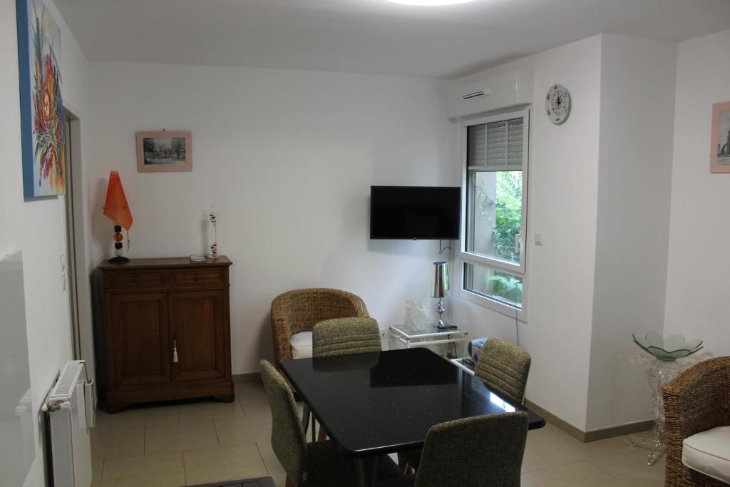 a living room with a dining room table and chairs at BIENVENUE EN BAIE De SOMME in Saint-Valery-sur-Somme