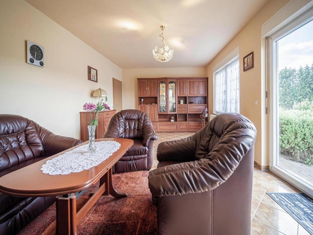 a living room with leather chairs and a table at Ferienhaus an der Wiese, Tanne in Tanne