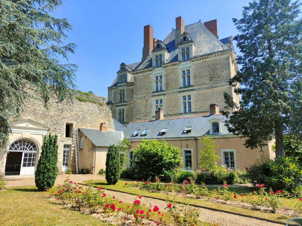 un grande castello con dei fiori davanti di Les Jardins de l'Orangerie a Durtal