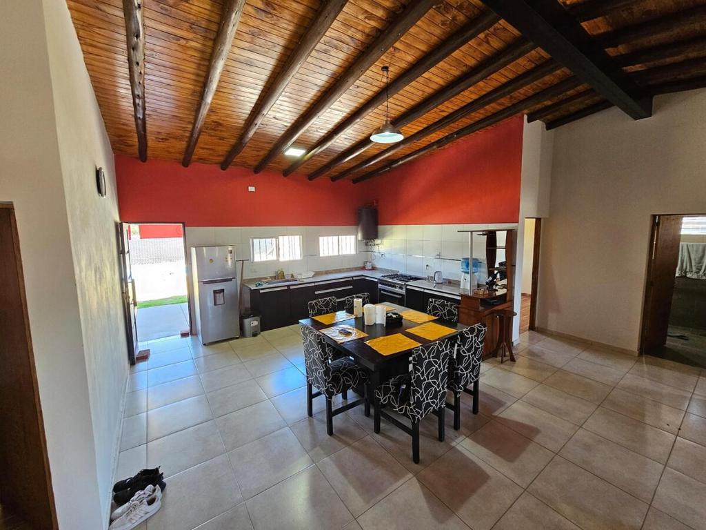 eine Küche mit roten Wänden und einem Tisch und Stühlen in der Unterkunft Cabaña Magus 6 personas con pileta in San Rafael