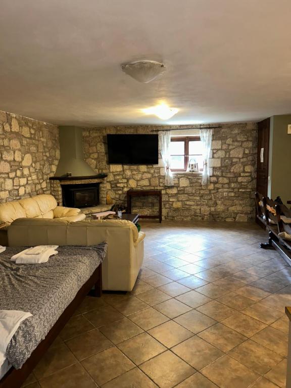 a living room with a couch and a stone wall at Saint George Apartments I & IV in Kalavrita