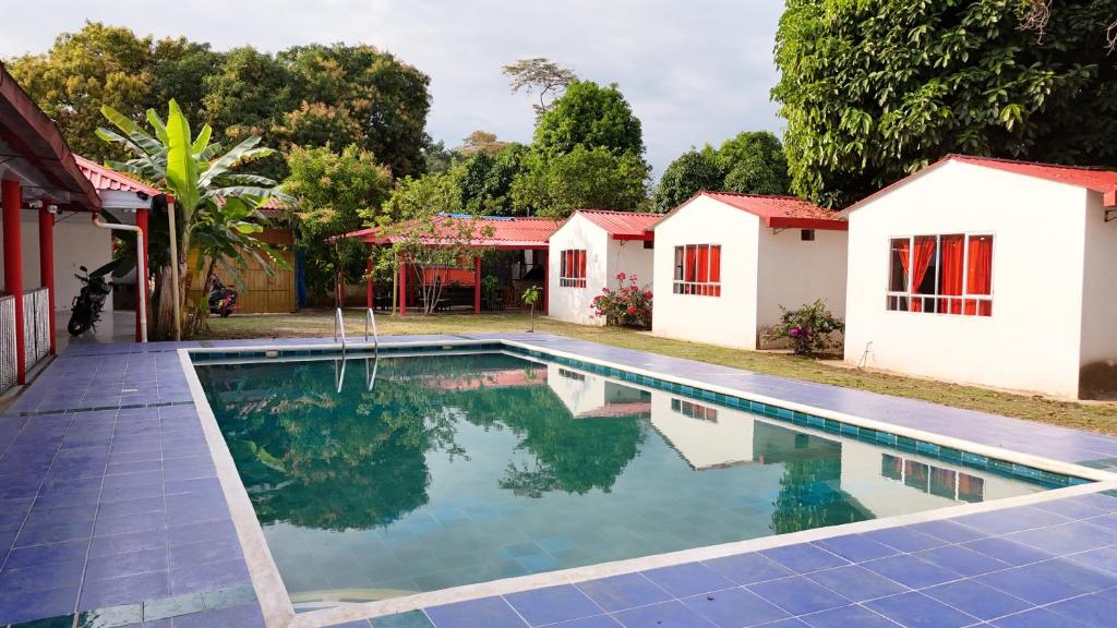 a swimming pool in front of a house at Cabañas el paraiso in Villavicencio