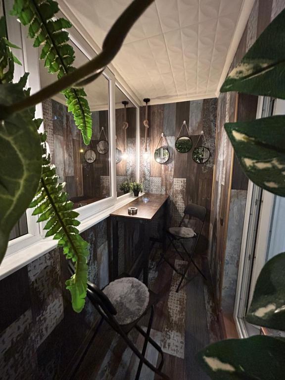 a room with a table and chairs and plants at Sara Suite in Sibiu
