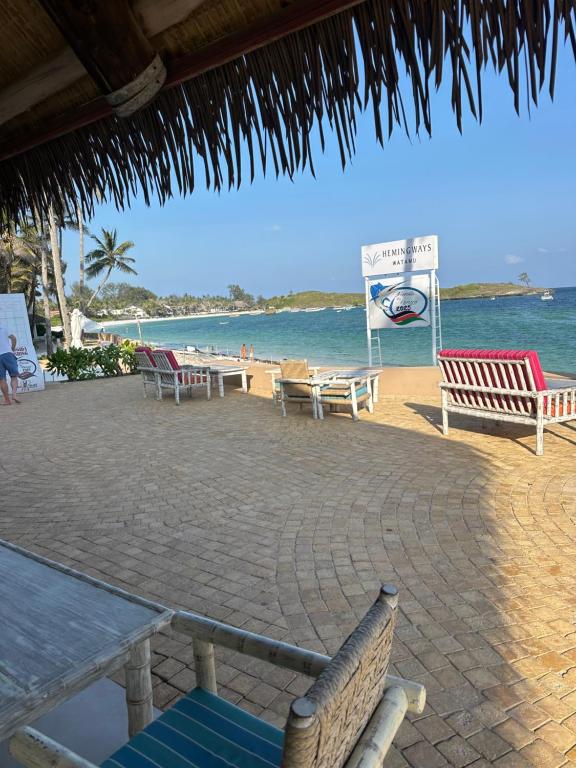 a beach with tables and chairs and the ocean at 2 bedroom luxury villa Diani in Galu