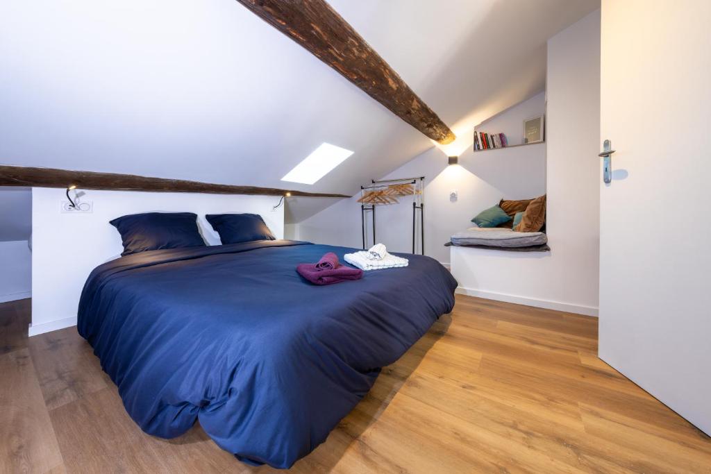 una camera da letto con un grande letto blu in una stanza di Neuf, confortable & atypique a Saint-Jean-de-Verges