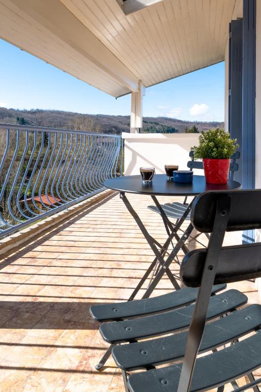 une table et des chaises sur un balcon avec vue dans l'établissement Neuf, confortable & atypique, à Saint-Jean-de-Verges