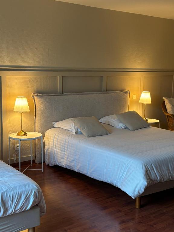 - une chambre avec 2 lits et 2 tables avec des lampes dans l'établissement Chambre Victory, à Colleville-sur-Mer