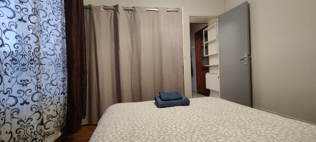 une chambre avec un lit avec une serviette bleue dessus dans l'établissement Cozy 1 Bedroom Apartment Easy Access to Paris and Expo, à Montrouge
