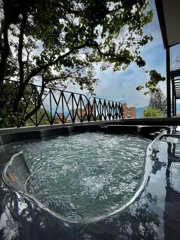 a hot tub with water in it with a tree at Nomadic Boutique Living and Experience Center in Medellín