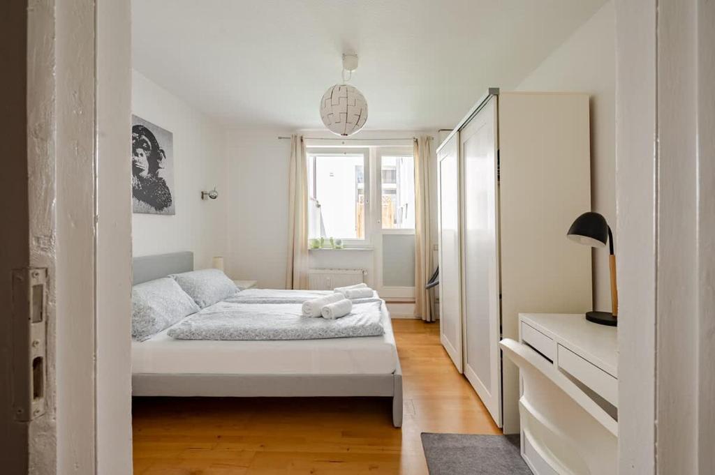 a white bedroom with a bed and a window at LOFT Fischkopf 3p NDR UKE ZOO in Hamburg