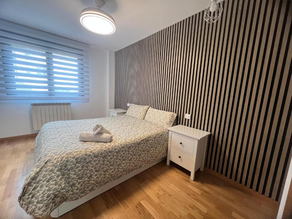 a bedroom with a bed and a wooden floor at El Llano I, parada en el destino in Puebla de Alfindén