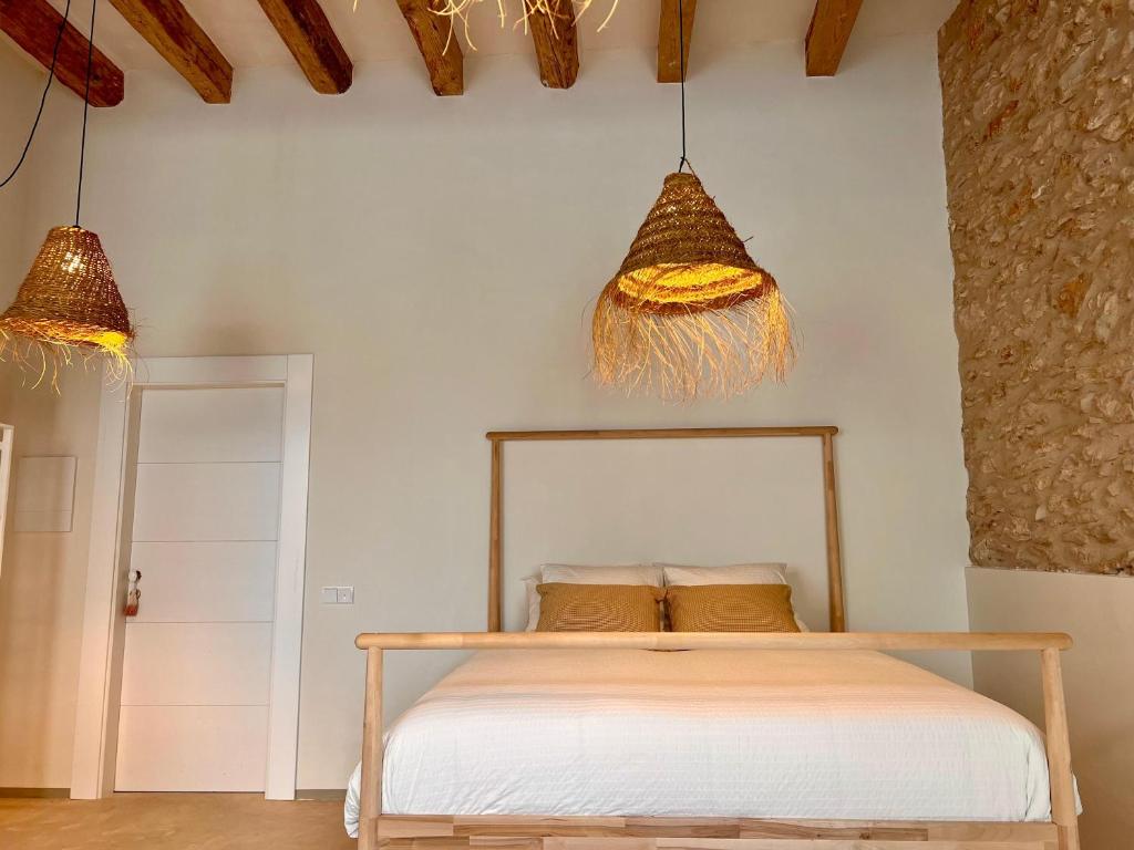 a bedroom with a bed and two pendant lights at Casa Anguila in Amposta